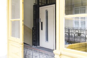 A door with a vertical handle and a small window above it. - Real Apartments M úzeum (Budapest)