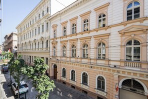 Un edificio de varios pisos con arquitectura clásica, que presenta ventanas en arco y molduras decorativas.