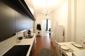 Apartament exclusiu | Cuina privada | Frigorífic, trona i una taula de menjador 