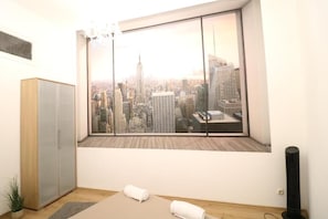 Enjoy a panoramic city view from the comfort of this stylish room, featuring a large window and a minimalist design.