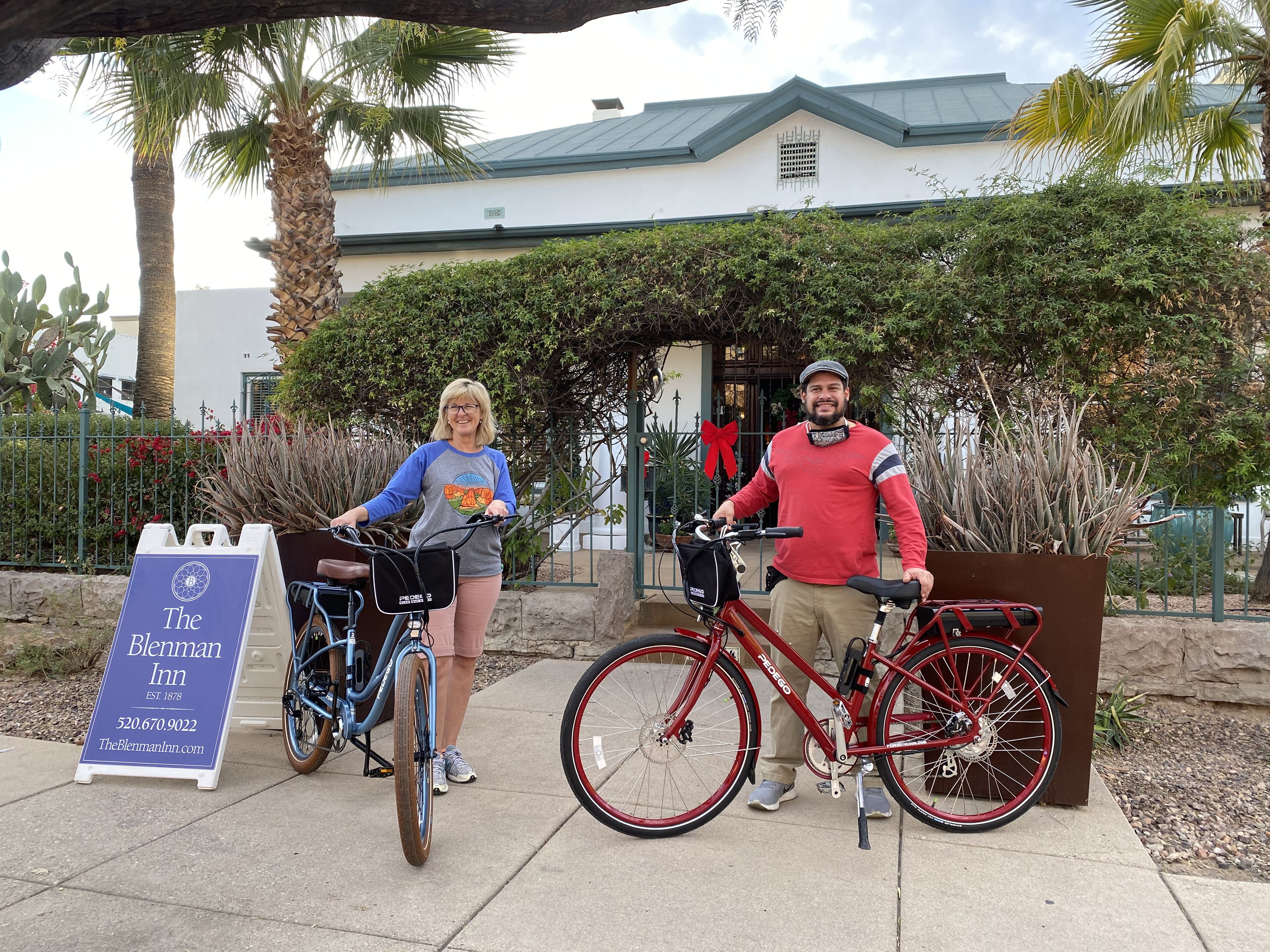 Two bicycles parked in front of a building with a signboard for The Blenman Inn.