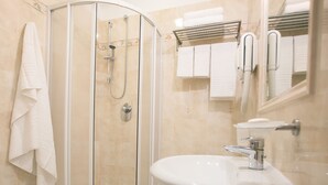 Ein Badezimmer mit Duschkabine, Waschbecken und Toilette.