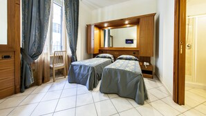 Ein Hotelzimmer mit zwei Betten, einem Holzschrank, einem Schreibtisch und einem Stuhl.
