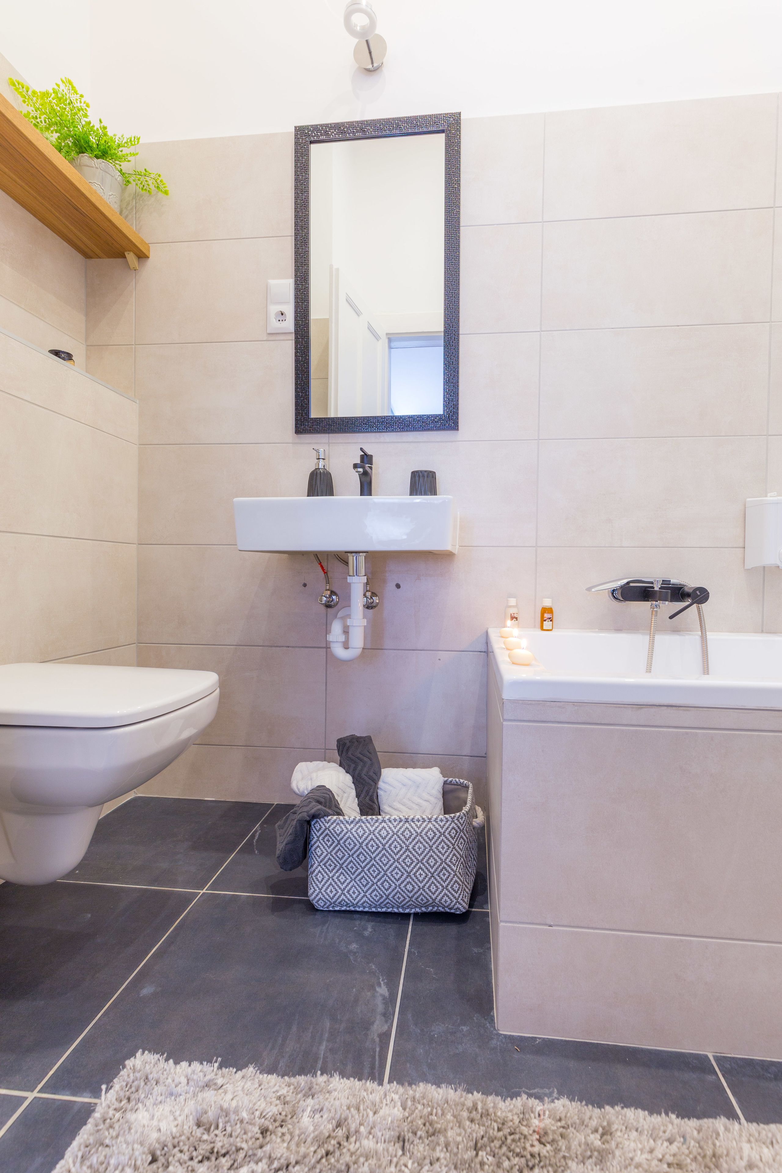 A modern bathroom with a toilet, sink, and bathtub.