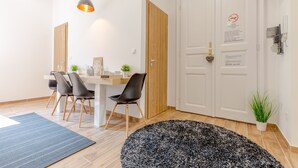 Una sala da pranzo moderna con un tavolo bianco, sedie nere e una porta in legno.