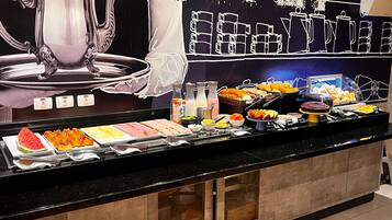 Een buffet met diverse gerechten en een grote decoratieve karaf.