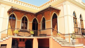 A building with a balcony, arched windows, and a staircase. - Pousada Estação do Trem (São João del Rei)