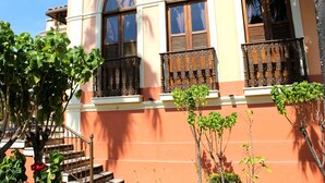 A building with three arched windows and ornate wooden balconies. - Pousada Estação do Trem (São João del Rei)