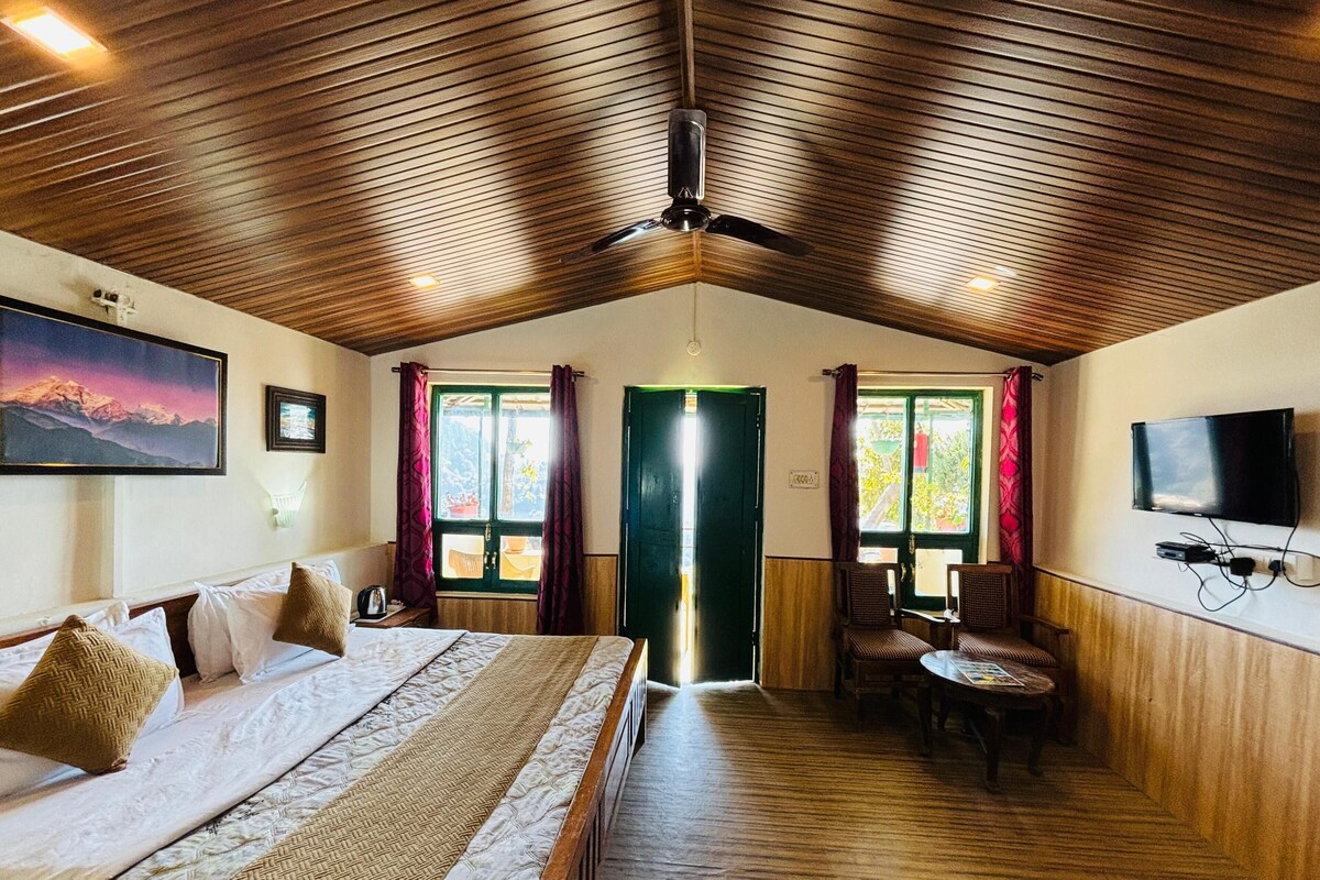 A spacious room with a bed, a television, and a dining area.