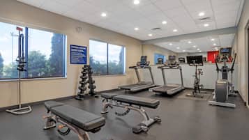 Ein Fitnessstudio mit Laufbändern, Crosstrainern und Gewichten.