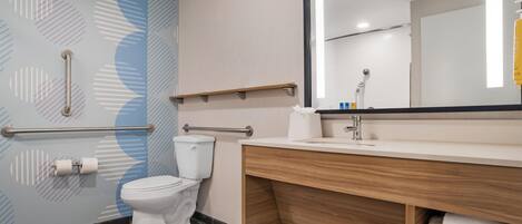 A modern bathroom with a toilet, a sink, and a mirror.