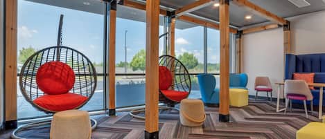 En modern inredning med hängstolar, en blå soffa och utsikt över omgivningen.