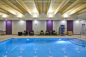 Una piscina techada, sillones reclinables de piscina