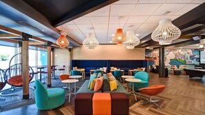Ein stilvoller Lounge-Bereich mit einer zentralen Sitzgruppe, Holzboden und modernen Leuchten.