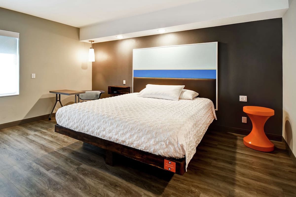 Une chambre à coucher moderne avec un grand lit, un bureau et une chaise.
