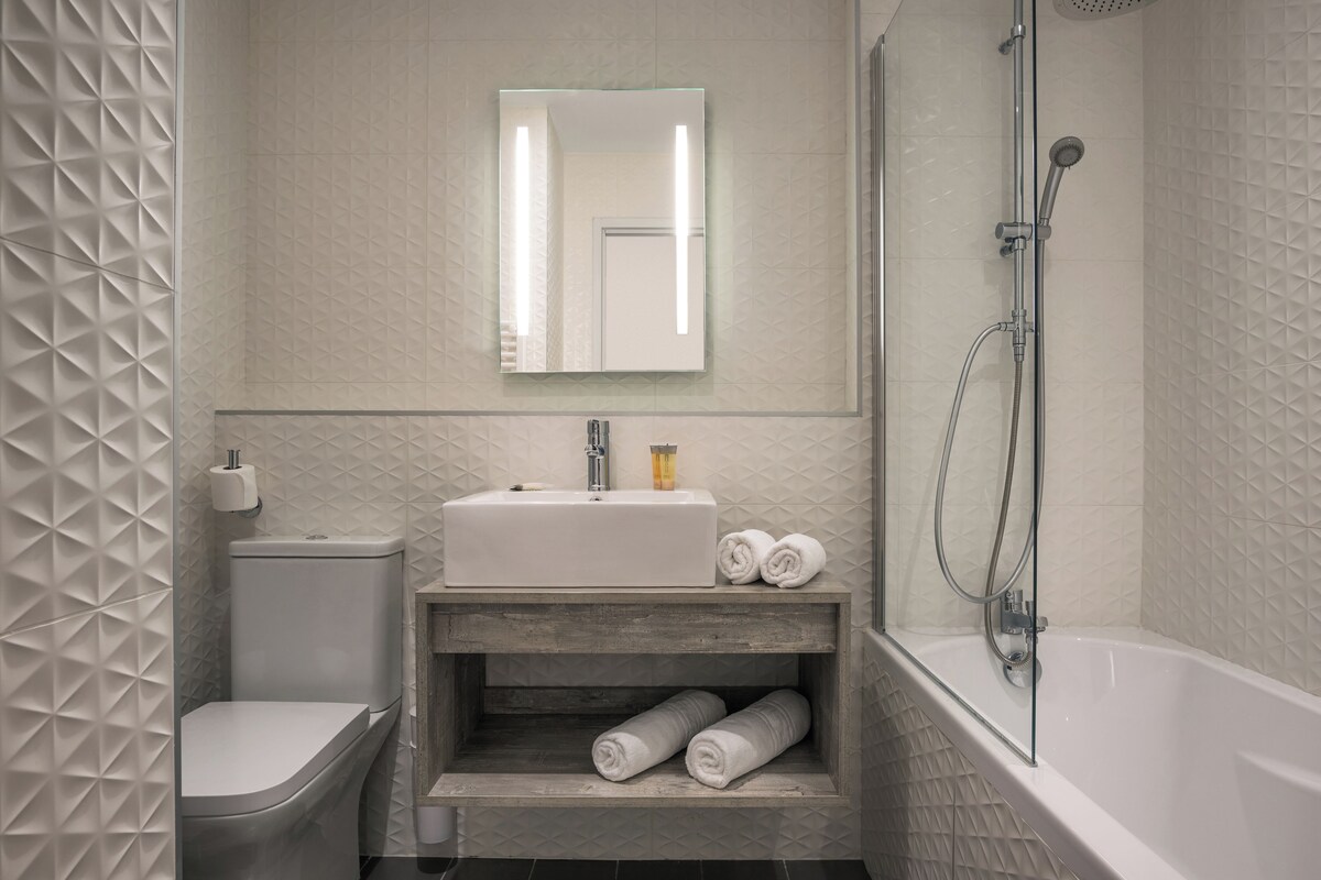 Un baño con inodoro, lavamanos y ducha.