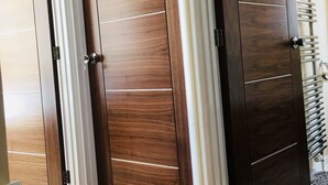 A room with a large wooden wardrobe, a white curtain, and a radiator. - Bianca's House Hotel Heathrow Airport (Slough)