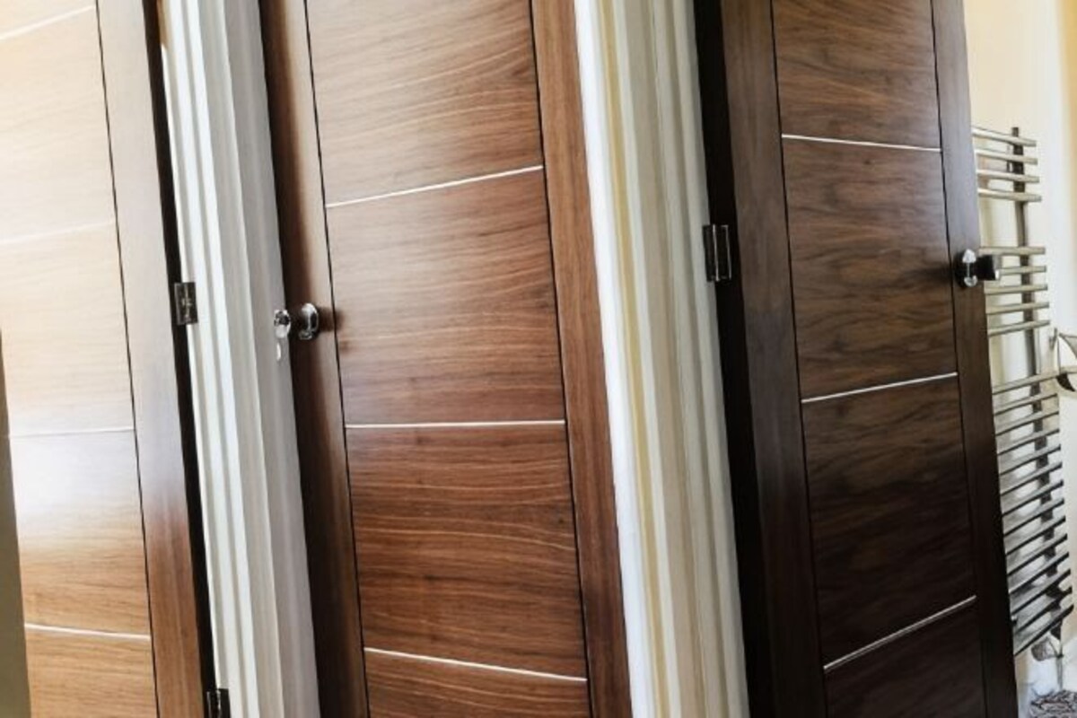 Un juego de puertas de armario de madera con diseño moderno, que presenta líneas horizontales y un separador vertical central.