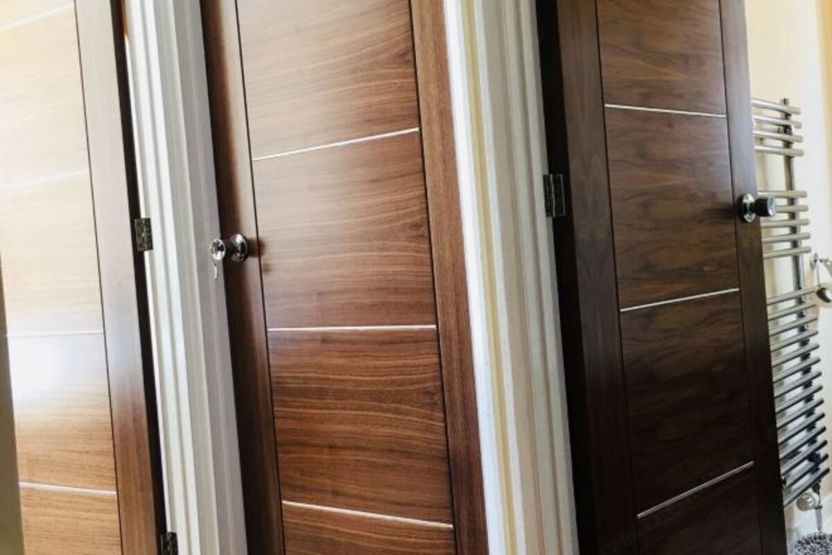Un conjunto de puertas de madera con diseño moderno, que combinan líneas verticales y horizontales.