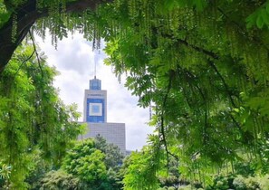 A building with a modern design, surrounded by lush greenery. - ibis Wenzhou University Hotel (Wenzhou)