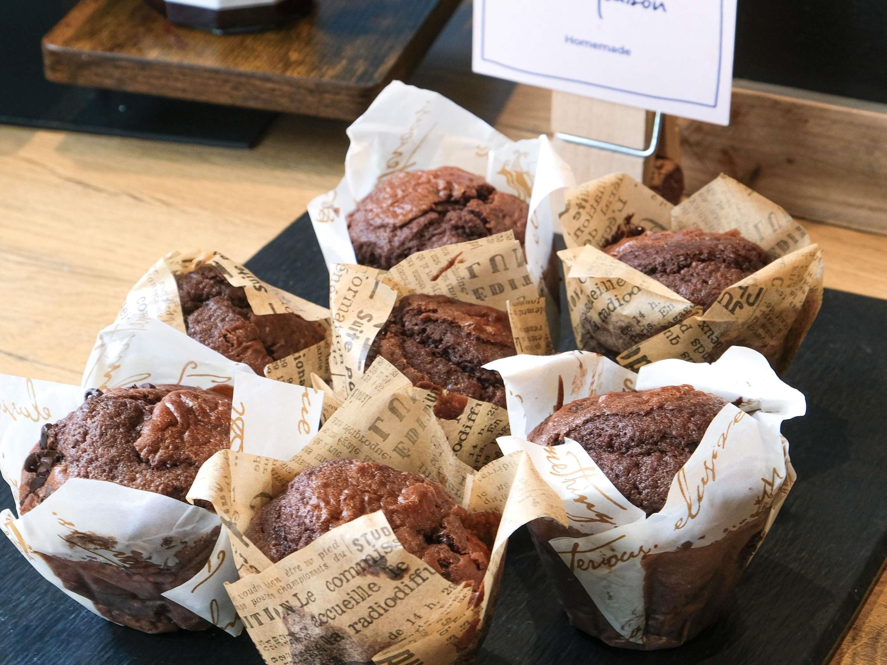 Una bandeja de brownies envueltos en papel con texto, sobre una superficie de madera.