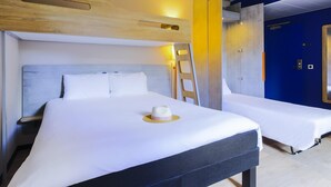 Habitación de hotel con dos camas, cabecera de madera, escalera y una puerta azul.