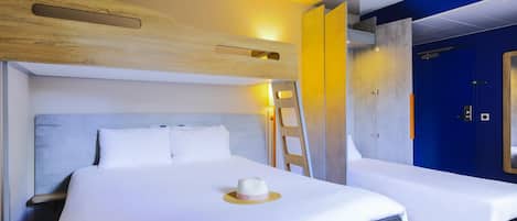 Habitación de hotel con dos camas, cabecera de madera, escalera y una puerta azul.