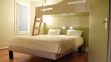Un dormitorio con literas, una ventana y una puerta.