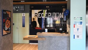 Un espace d’accueil doté d’un plancher en bois, d’un comptoir de réception et d’une enseigne fixée au mur sur laquelle on peut lire « RÉCEPTION ».