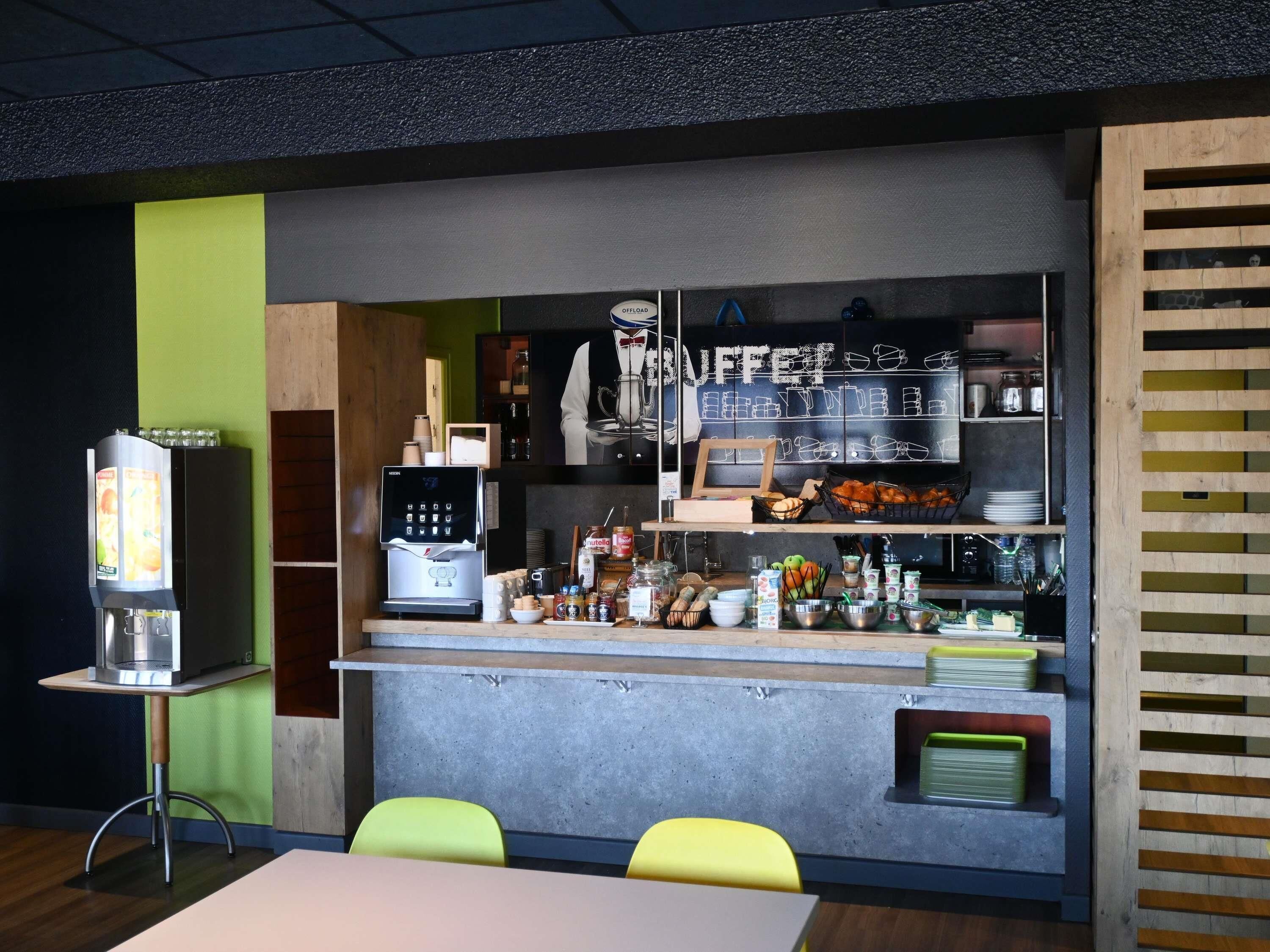 A bar area with a coffee machine, a buffet counter, and seating.