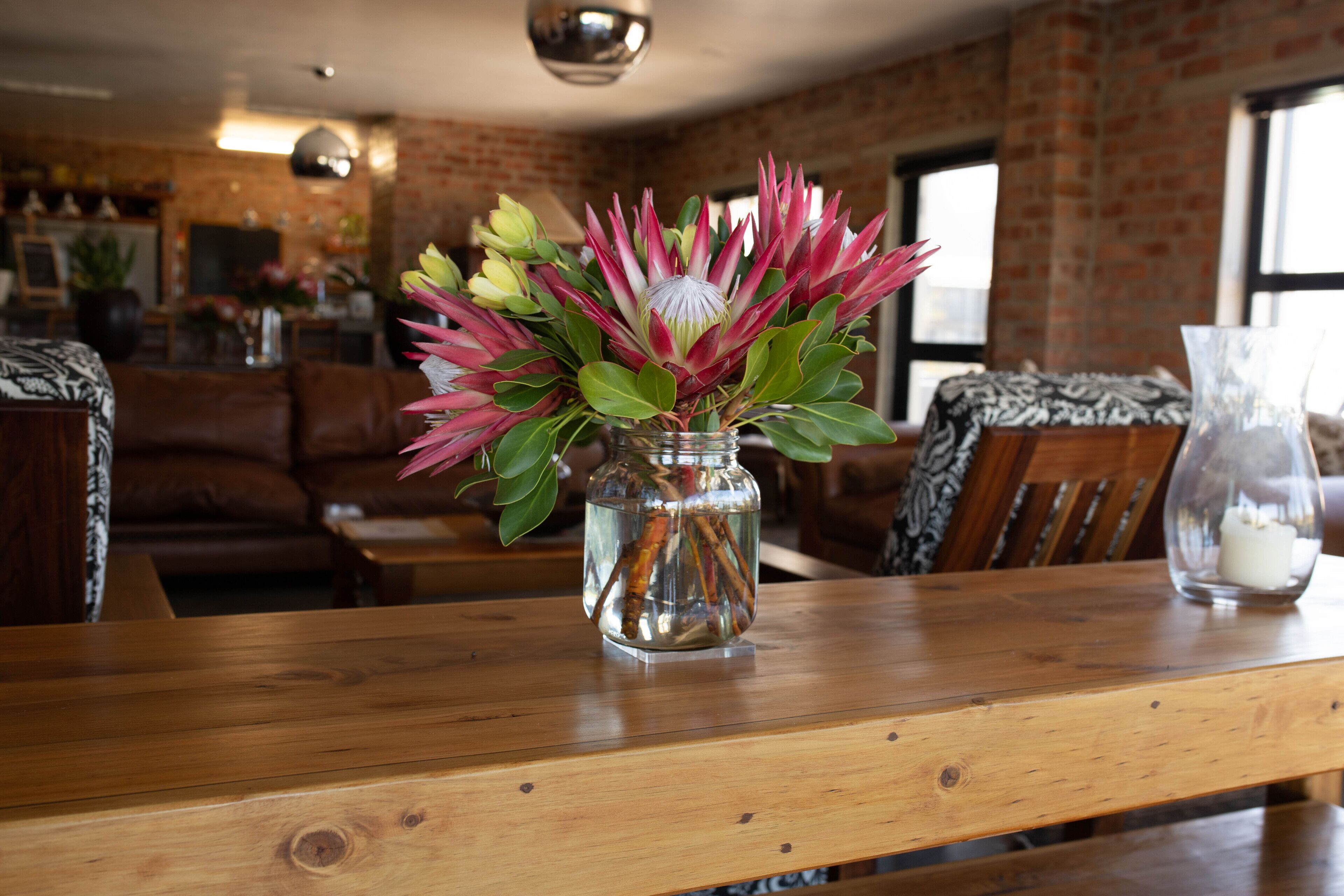 Une table en bois sur laquelle se trouve un vase en verre contenant un bouquet de fleurs.