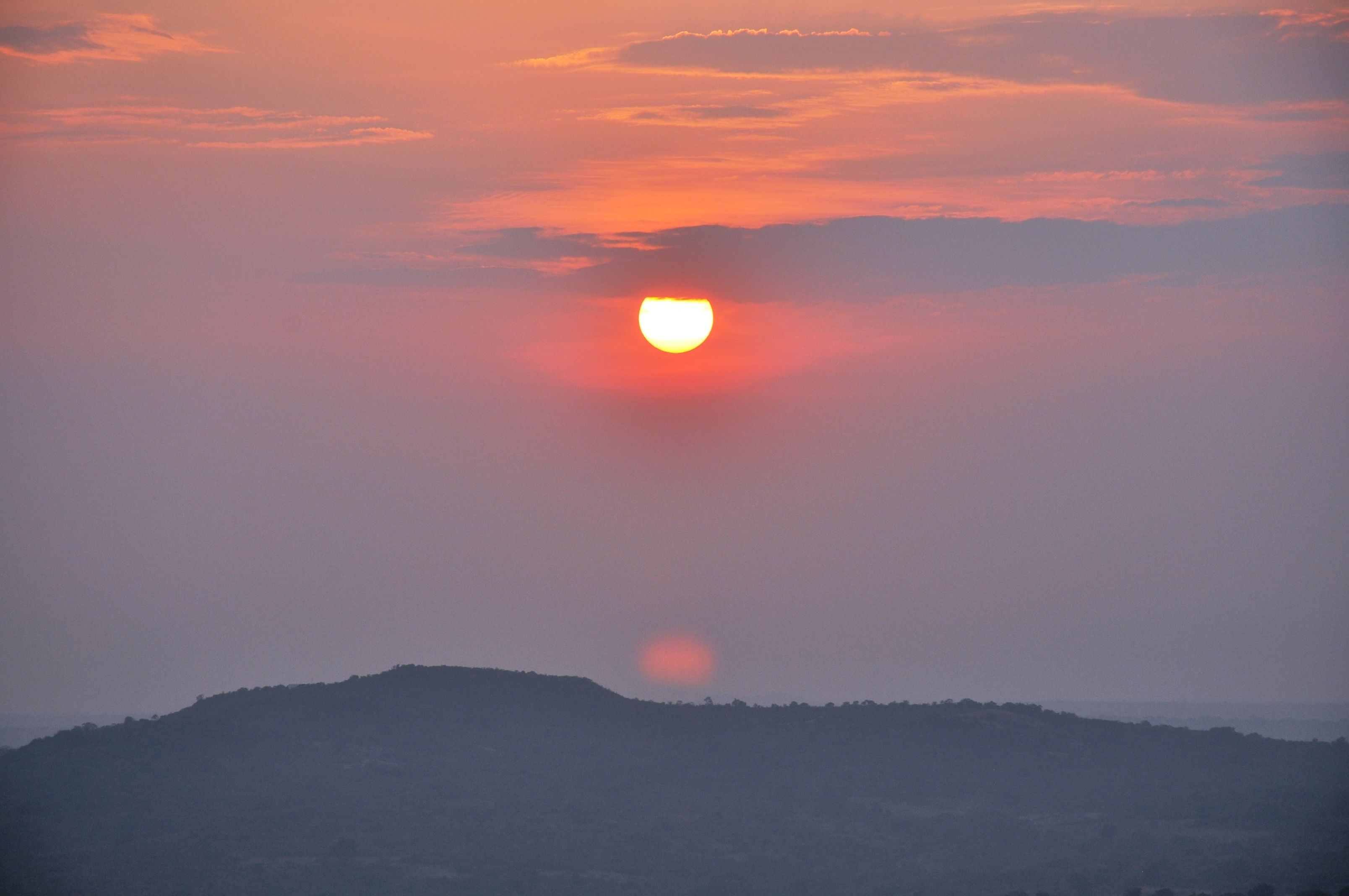 Un atardecer sobre un paisaje montañoso.