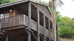 Une structure en bois dotée d’un balcon et d’un toit de chaume.