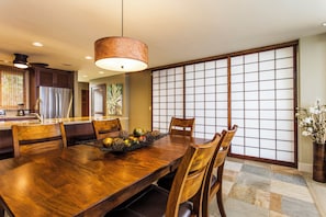 A dining area with a wooden table, chairs, and a decorative fruit bowl.