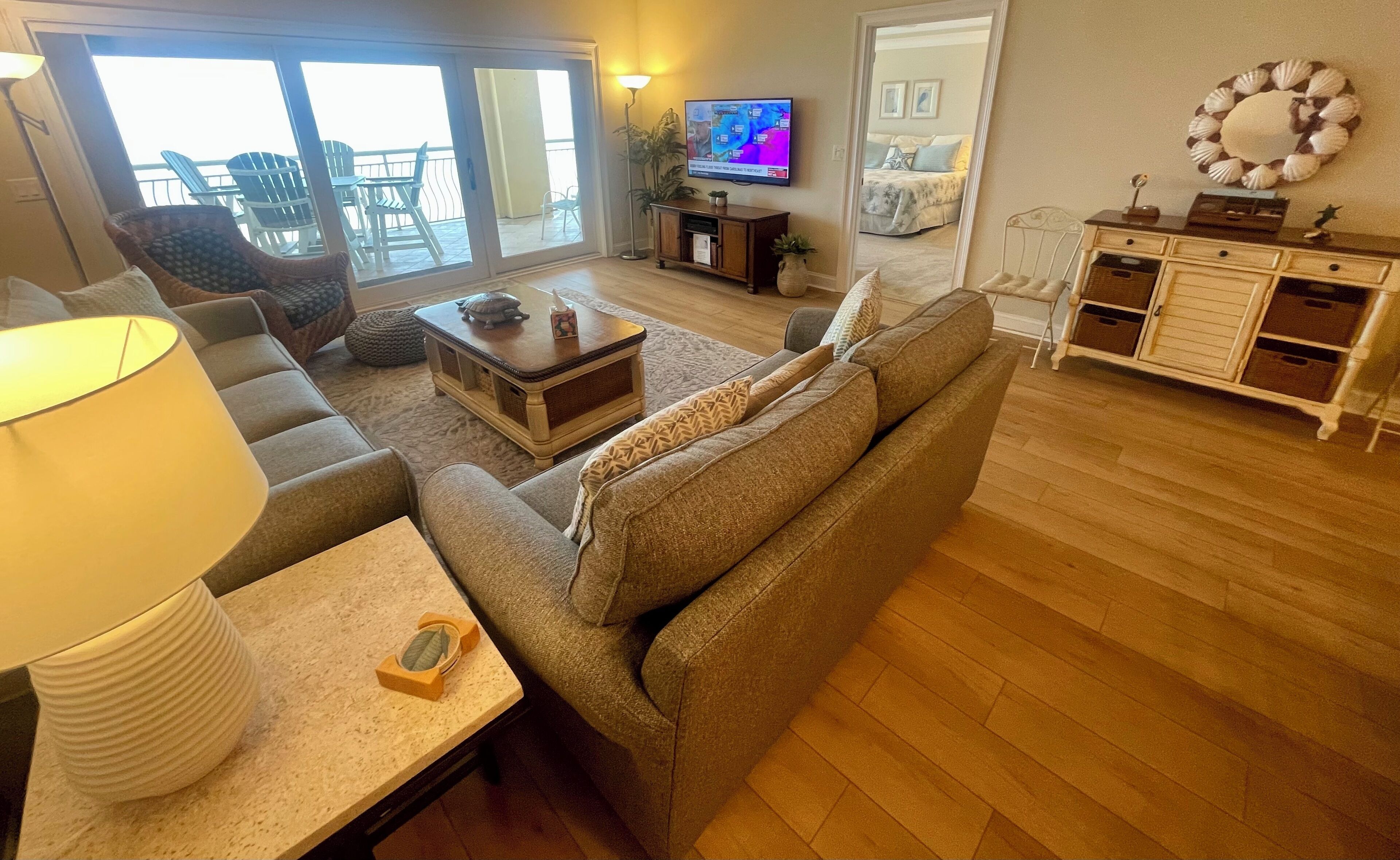 Una sala de estar con sofá, mesa de centro, lámpara y televisor.