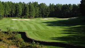 A golf course with sand bunkers, a well-maintained fairway, and a dense forest in the background. - Bearfoot Memories: 180 Degree Views, Hot Tub (Gatlinburg)