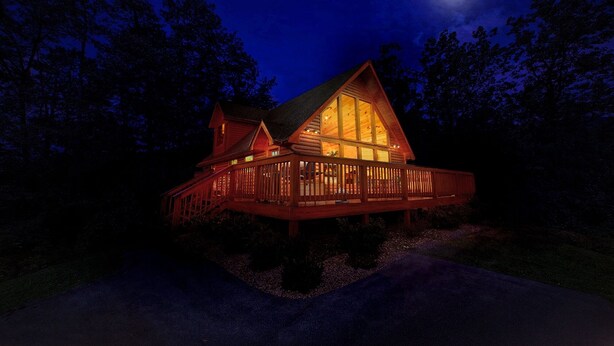 A wooden cabin with a large window and a balcony, surrounded by trees. - Bearfoot Memories: 180 Degree Views, Hot Tub (Gatlinburg)