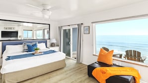 A bedroom with a bed, a nightstand, a lamp, a TV, a sliding glass door to a balcony, and a view of the ocean. - Bluff-Top Beauty With Ocean Views - 1086 (Encinitas)