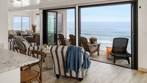 A spacious living area with a large sliding glass door leading to a balcony with ocean views. - Bluff-Top Beauty With Ocean Views - 1086 (Encinitas)