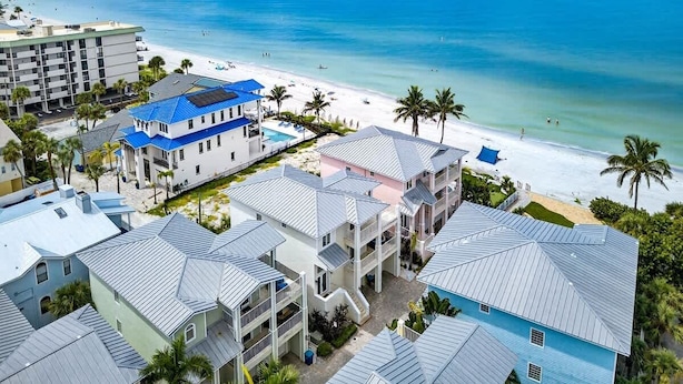 A beachfront hotel with multiple buildings, a pool, and a beach view. - Isla Bonita 4BR Villa in Indian Rocks Beach (Indian Rocks Beach)
