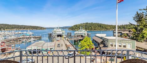 A waterfront view with a dock, boats, and a flag.