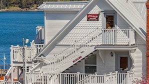 A white building with a balcony and a sign indicating lodging availability. - San Juan Island, Yakima Suite #1901 (Friday Harbor)