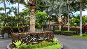 A sign for 'The Fairways Restaurant & Bar' with a stone base, surrounded by lush greenery and palm trees. - 🏖️Luxurious View Corner Townhome | Great Views | VIP Beach Pass (Kamuela)