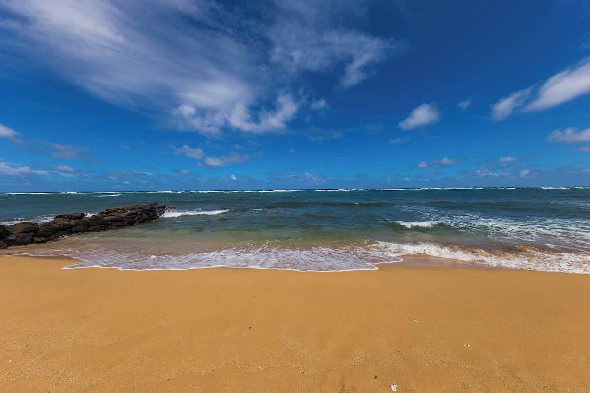 A beach with clear skies and calm waves.