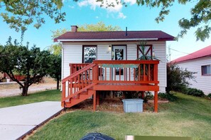 A small, single-story house with a red front porch and a chimney. - Hot Tub, Kokopelli Kabyn, Cute and Cozy! (Blanding)