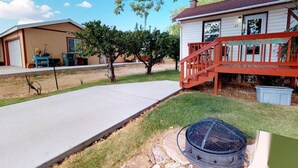 A residential property with a paved driveway, a wooden deck, and a small outdoor grill area. - Hot Tub, Kokopelli Kabyn, Cute and Cozy! (Blanding)