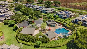 Un barrio residencial con varias casas, una piscina y paneles solares en los tejados.
