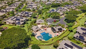 Un barrio residencial con varias casas, una piscina y vistas al océano.