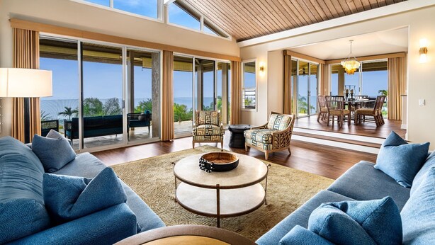 A spacious living area with a large round coffee table, comfortable seating, and a view of the outdoors.