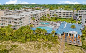 A resort with multiple buildings, a swimming pool, and a beach area.